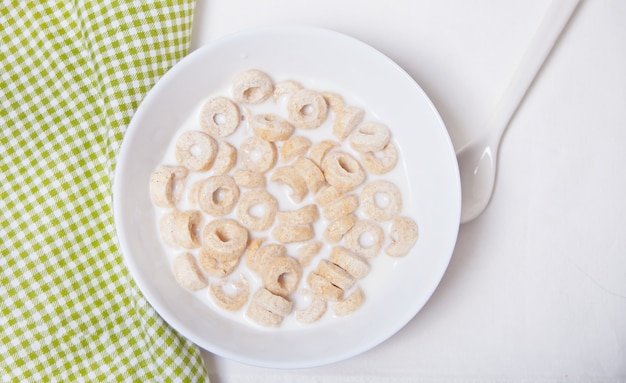 Köstliche und nahrhafte Müslischleifen in einer Schüssel mit Milch zum gesundes Frühstück für Kinder
