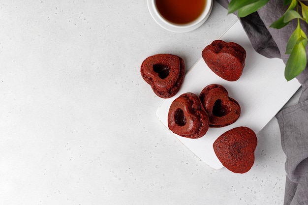 Köstliche Valentinstagkleine kuchen auf weißer Platte und weißem Hintergrund. Ansicht von oben. Muffins in Herzform