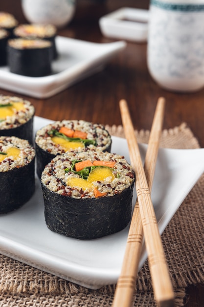 Köstliche vegane Sushi-Rolle mit Holzstäbchen