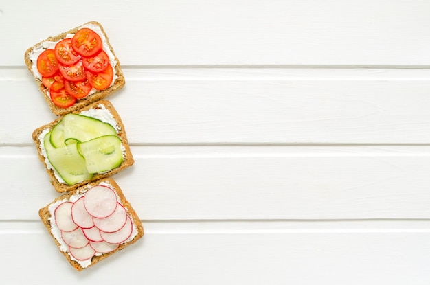 Foto köstliche vegetarische sandwiches mit frischkäse, frischen gurken-rettich-tomaten