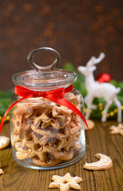 Köstliche Weihnachtsplätzchen im Glas auf dem Tisch auf braunem Hintergrund