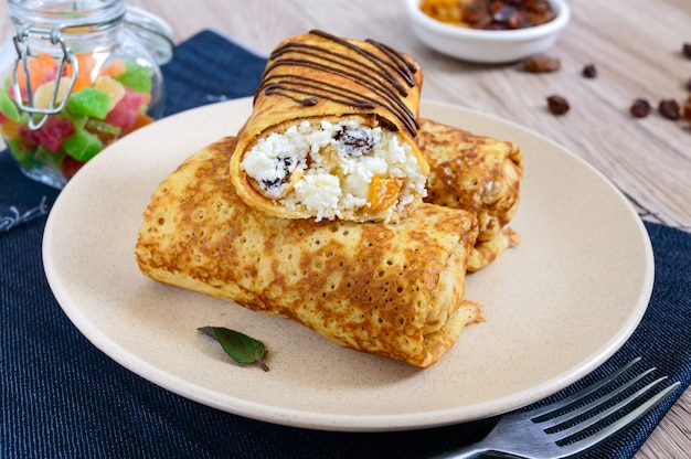 Köstliche zarte Pfannkuchen mit Quark, Vanille und Rosinen auf einem Teller. Gesundes Frühstück.