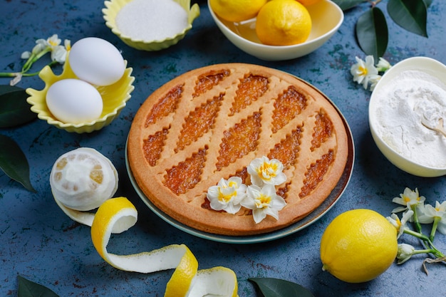 Köstliche Zitronenkuchen mit frischen Zitronen auf Beton, Draufsicht