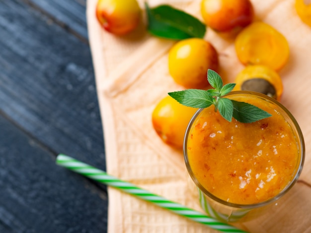 Köstlicher Aprikosen-Smoothie in einem Glas mit einem Strohhalm