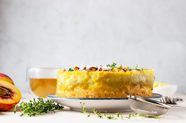 Köstlicher Chiffon-Kuchen mit Puddingcreme und Nektarinen mit Kräutertee und Thymian.