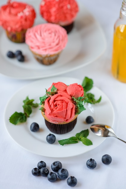Köstlicher Cupcake auf einem weißen Teller auf weißem Hintergrund.