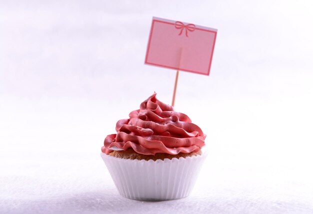 Foto köstlicher cupcake mit inschrift auf dem tisch auf beigem hintergrund