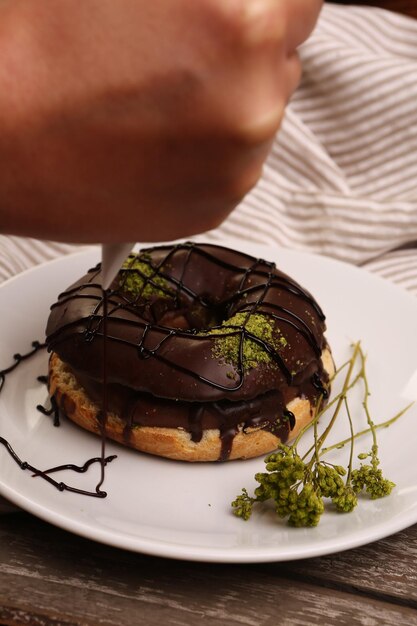 Köstlicher Donut mit Schokoladensauce und Pistazienstückchen