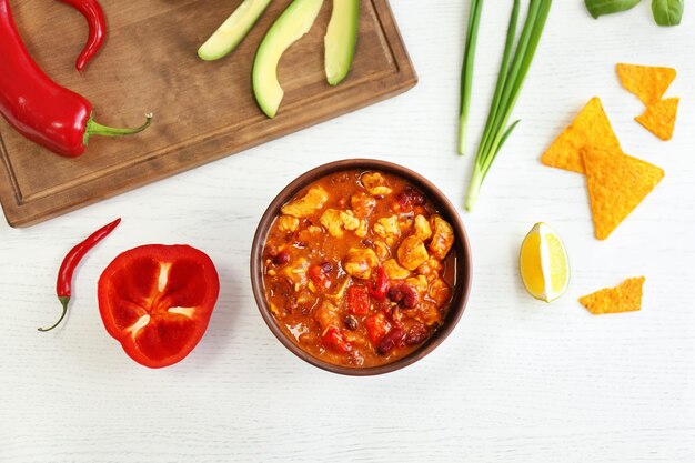 Foto köstlicher fleischeintopf, frisches gemüse und nachos auf dem tisch