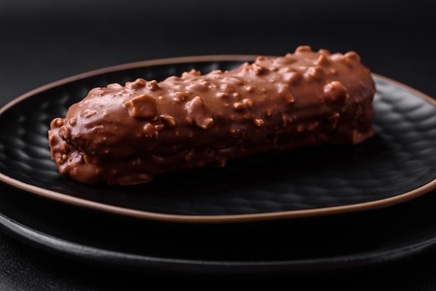 Köstlicher frischer Eclair-Kuchen oder Kränzchen mit Schokolade und Nüssen