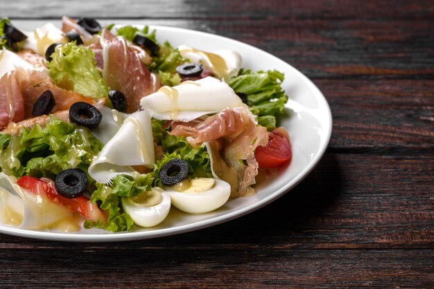 Köstlicher frischer Salat mit Speck für die festliche Tafel. Vorbereitung auf den Familienurlaub