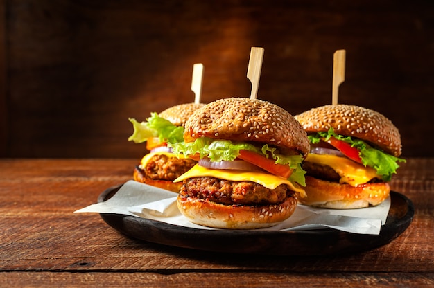 Köstlicher frischer selbst gemachter Burger auf hölzerner Platte