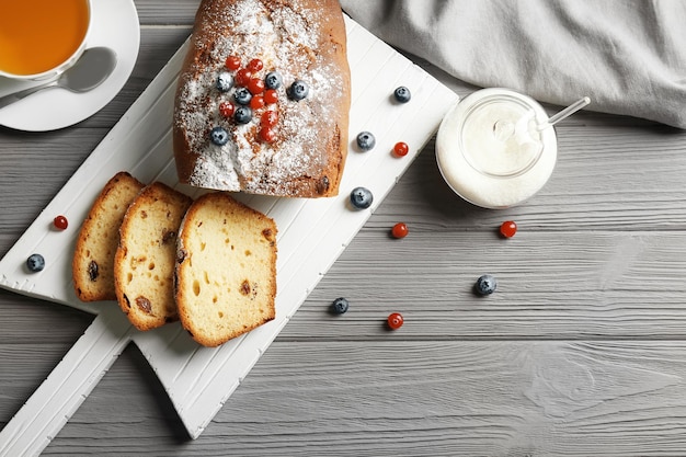 Köstlicher geschnittener Joghurtkuchen mit Beeren auf weißem Schneidebrett