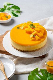 Köstlicher glasierter mango-käsekuchen ohne gebackenen käsekuchen mit frisch gewürfeltem mango-fruchtfleisch auf hellem tischhintergrund