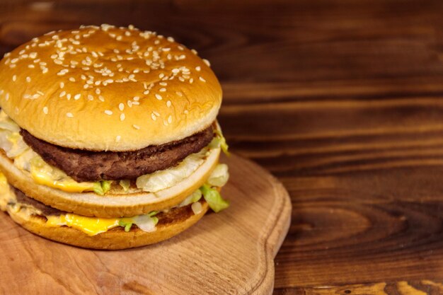 Köstlicher großer Hamburger auf Holztisch