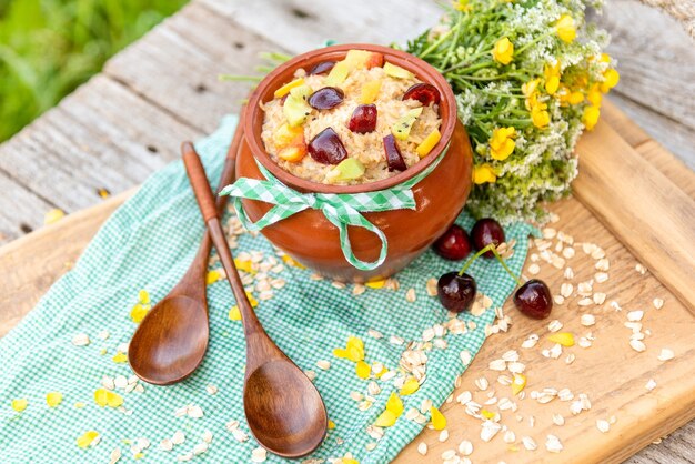 Köstlicher Haferbrei mit Beeren zum Frühstück in einem Tontopf.