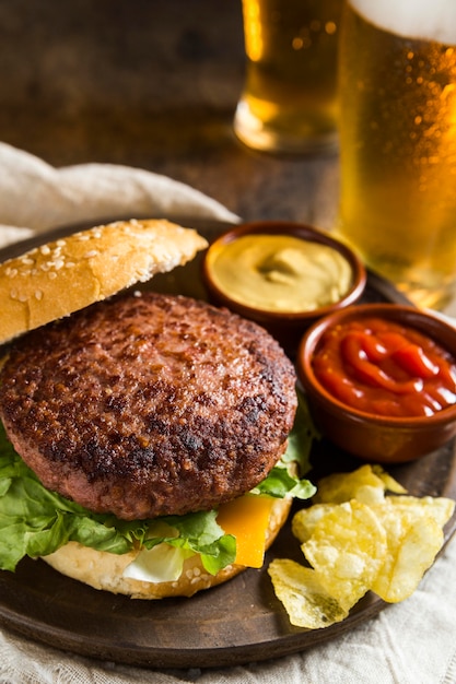Köstlicher Hamburger mit Gläsern Bier und Senf