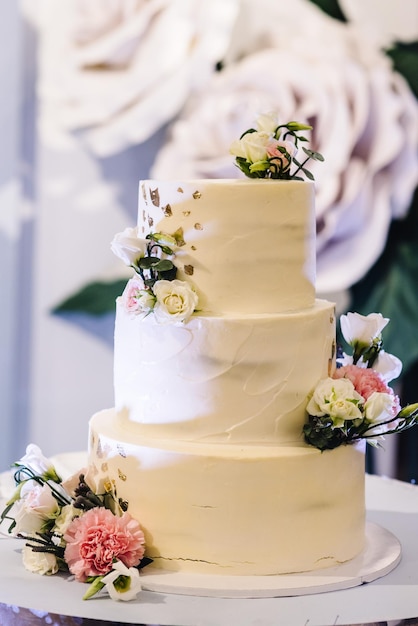 Köstlicher Hochzeitsempfang Kuchen mit Blumendekoration auf einem Hintergrund Partydekor Kopierbereich Feierkonzept Trendiger Kuchen Nahaufnahme