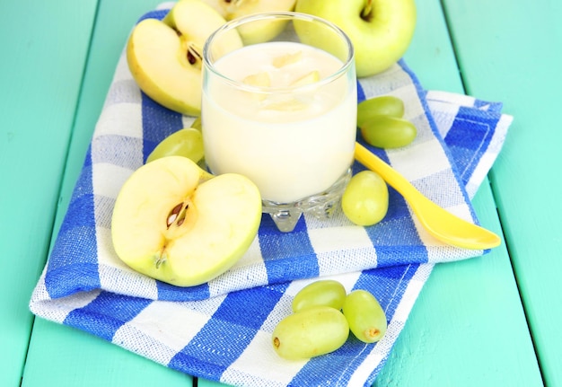 Köstlicher Joghurt im Glas mit Früchten auf Holztisch in der Nähe