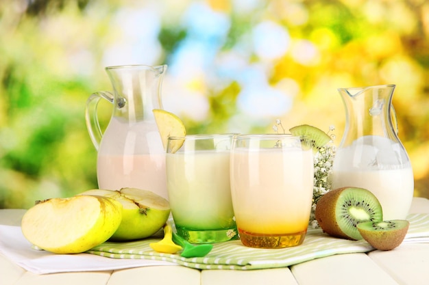 Köstlicher Joghurt mit Früchten in Gläsern auf Holztisch auf natürlichem Hintergrund