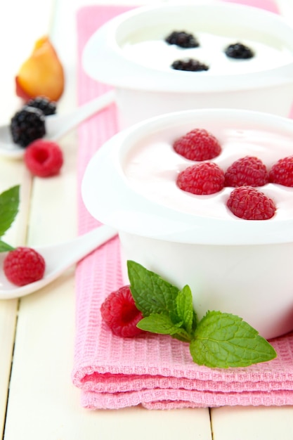 Köstlicher Joghurt mit Früchten und Beeren auf dem Tisch in der Nähe