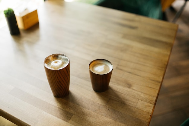 Köstlicher Kaffee und Cappuccino auf dem Tisch in einem Café Guten Morgen Holztisch Gläser stehen auf einem Holztisch