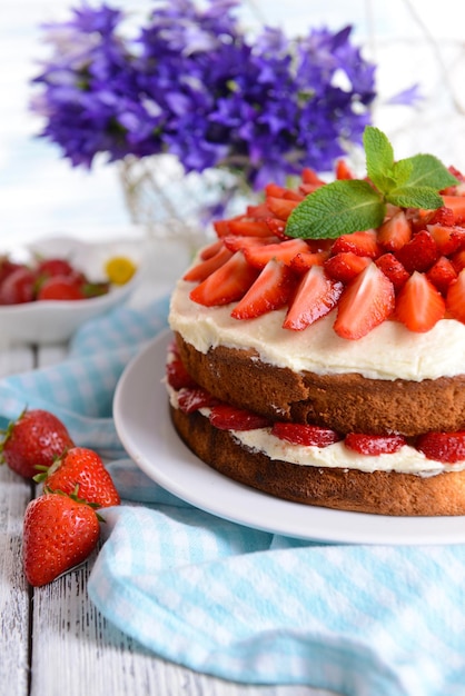 Köstlicher Keks mit Erdbeeren auf dem Tisch vor hellem Hintergrund