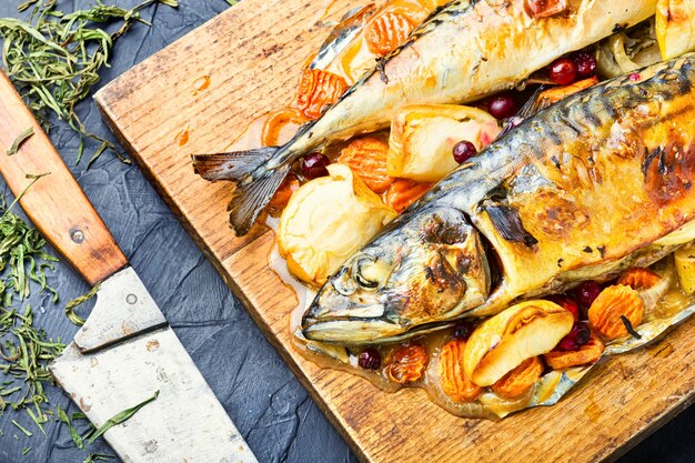 Köstlicher Makrelenfisch mit Äpfeln gebacken, serviert auf einem Küchenbrett.