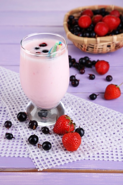 Köstlicher Milchshake mit Brombeere und Erdbeeren auf Holztisch in der Nähe