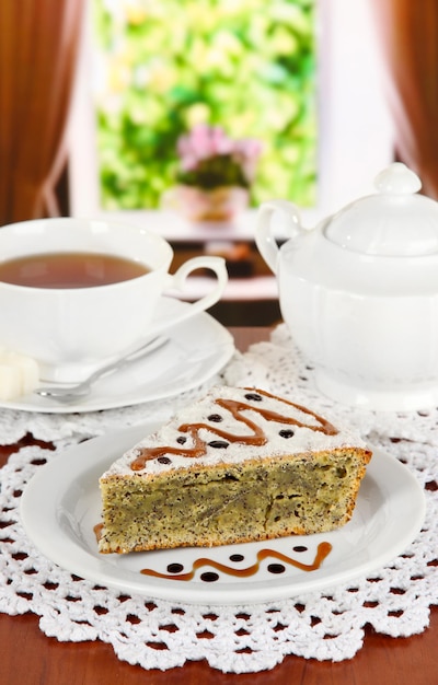 Köstlicher Mohnkuchen mit einer Tasse Tee auf dem Tisch im Zimmer