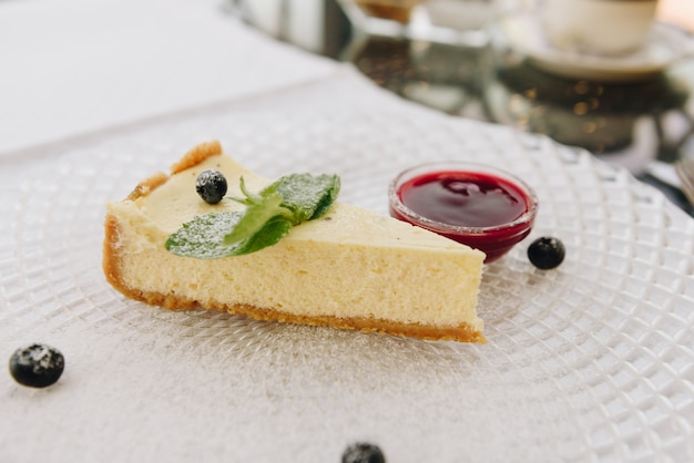 Köstlicher New- Yorkkäsekuchen auf einer Platte mit Beerensoße