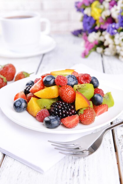 Köstlicher Obstsalat im Teller auf dem Tisch in der Nähe