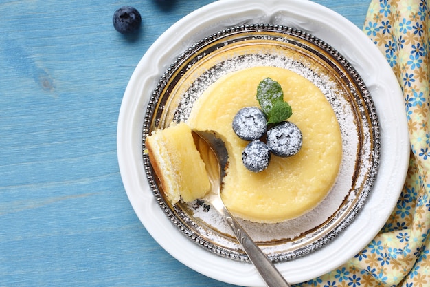 Köstlicher Puddingkuchen der Zitrone diente mit Beeren auf Platte