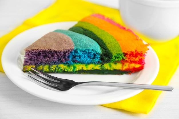 Foto köstlicher regenbogenkuchen auf platte auf hellem hintergrund