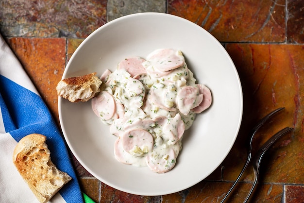 Köstlicher Salat aus einer Mischung aus gehackten Würsten, Gewürzen, Sauerrahm und Kartoffeln