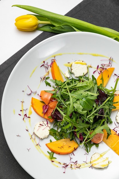 Köstlicher Salat mit Feigenarugula und Ziegenkäse auf Draufsicht der weißen Platte