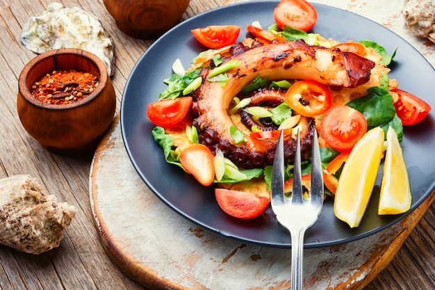 Köstlicher Salat mit Oktopus, Paprika, Tomaten und Gemüse.Salat mit Meeresfrüchten