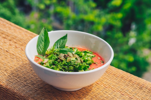 Köstlicher schöner roher veganer Salat aus grünen Blättern Mischgemüse in weißem Teller Kochrezept Gemischte Tomate Karotte Blumenkohl Schnitt Petersilie Koriander Dillgrün Gurke Basilikum Kürbiskerne