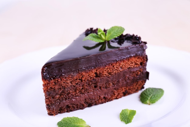 Köstlicher Schokoladenkuchen auf Teller auf hellem Hintergrund