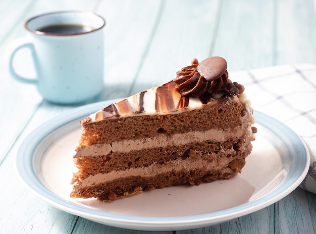 Köstlicher Schokoladenkuchen mit flauschigem Kakaobiskuit und Glasur mit Marmoreffekt zu einer Tasse Kaffee