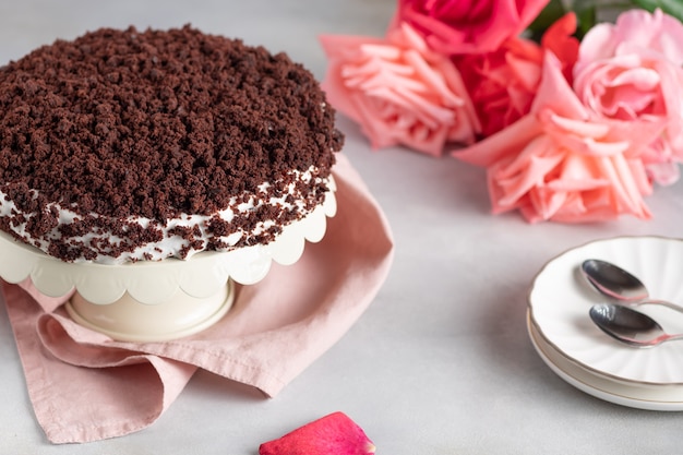 Köstlicher Schokoladenkuchen mit Sahne mit Rosenstrauß