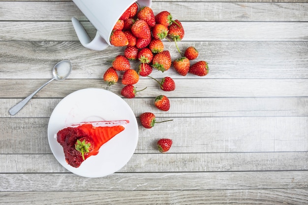 Köstlicher selbst gemachter Käsekuchen mit Erdbeeren auf Holztisch