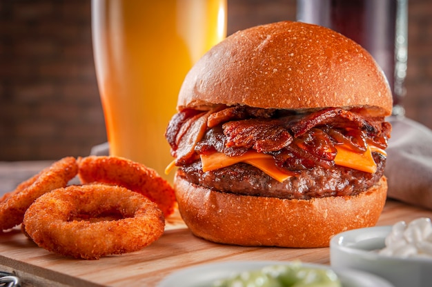 Köstlicher Speckburger mit Zwiebelringen und Bier.