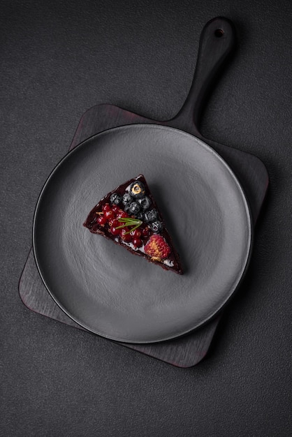 Köstlicher süßer Schokoladen-Brownie-Kuchen mit Heidelbeeren, Johannisbeeren und Himbeeren auf einem Keramikteller