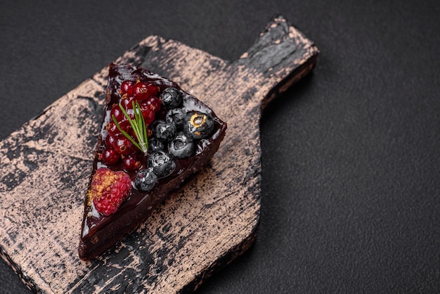 Köstlicher süßer Schokoladen-Brownie-Kuchen mit Heidelbeeren, Johannisbeeren und Himbeeren auf einem Keramikteller