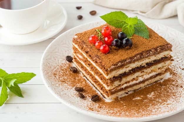 Köstlicher Tiramisukuchen mit frischen Beeren und Minze auf einer Platte