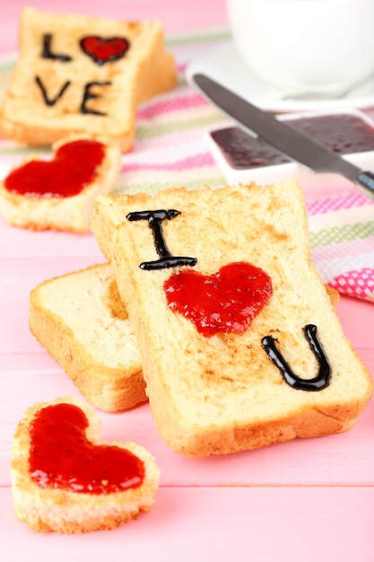 Köstlicher Toast mit Marmelade und Tasse Tee auf Tischnahaufnahme