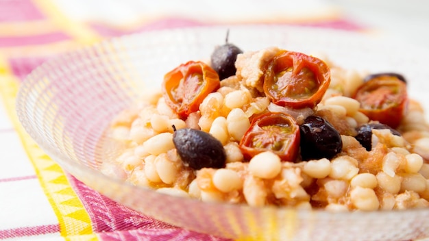 Köstlicher und gesunder weißer Bohnensalat mit Kabeljau und schwarzen Oliven