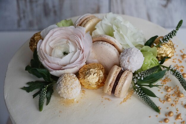 Köstlicher und schöner Hochzeitsnachtisch für eine Familienbäckerei mit einem goldenen Blumendekorationsabschluß oben