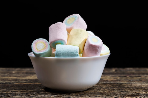 Köstlicher und süßer Marshmallow, Konfekt mit heißem Kaffee, Frühstück mit Kaffee und Süßigkeiten. Marshmallow wird in verschiedenen Farben mit zylindrischer Form hergestellt